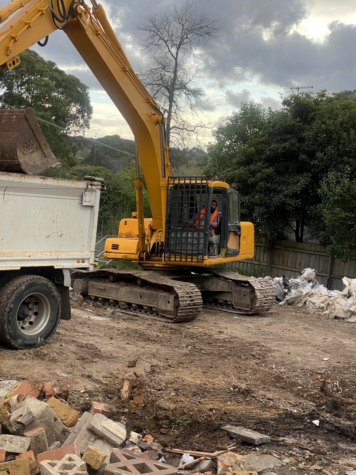 Excavator working beside truck